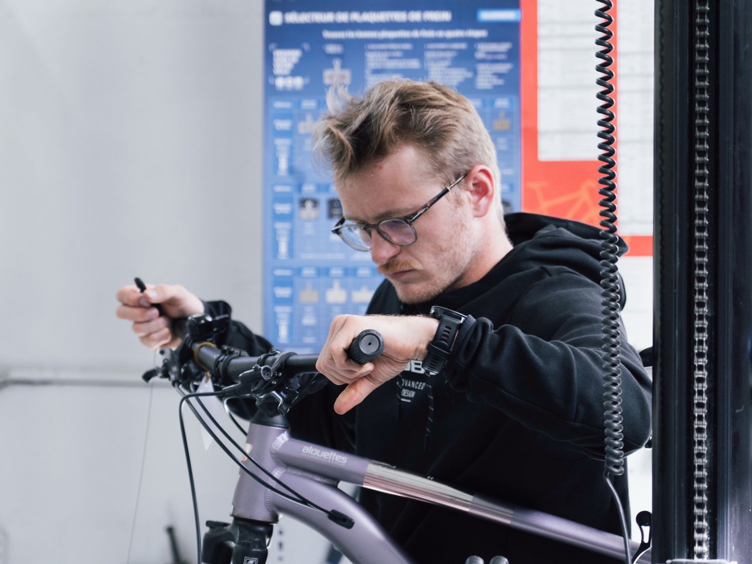 Mécanicien travaillant sur un vélo électrique au pied d’atelier
