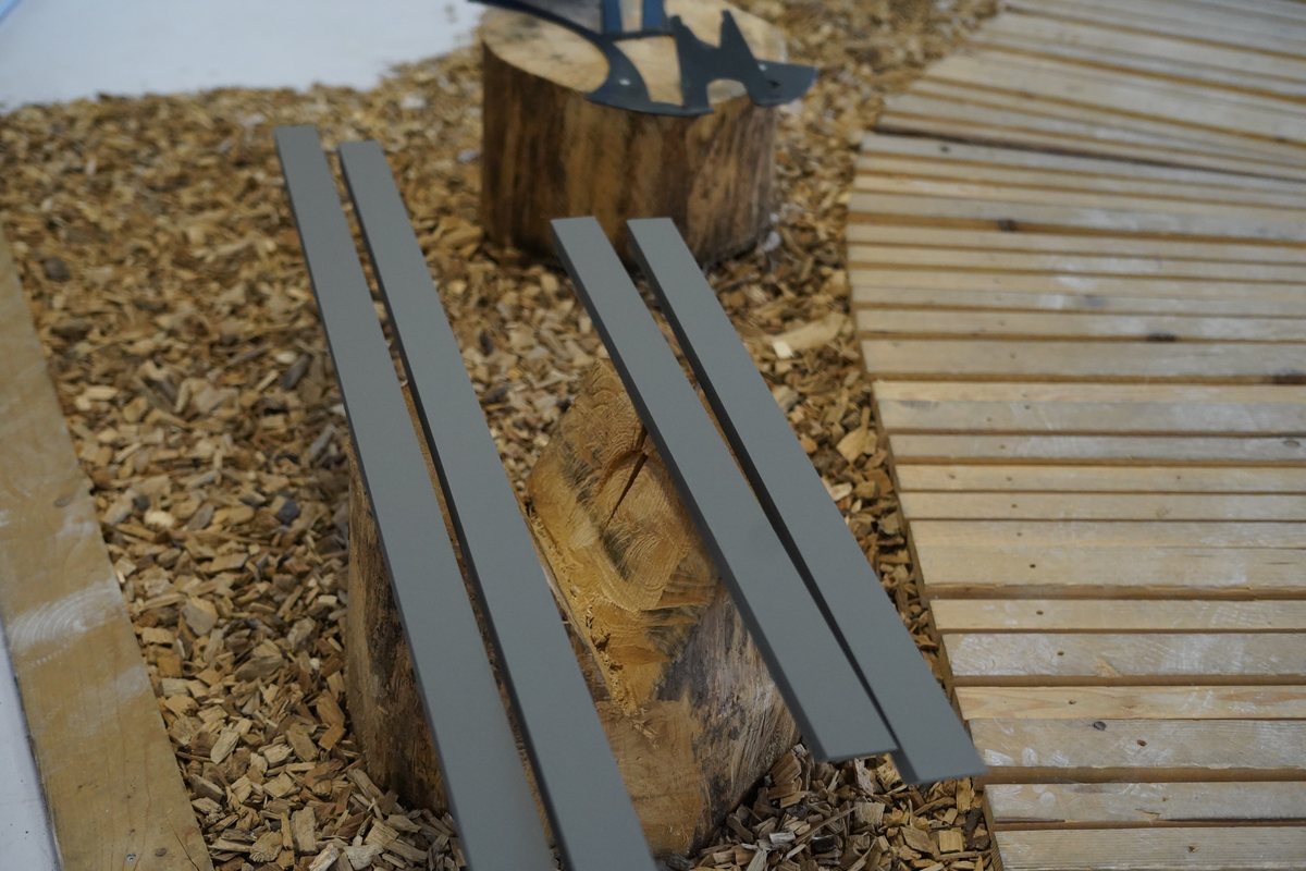 Détail : copeaux de bois, tronc et rails dans le showroom