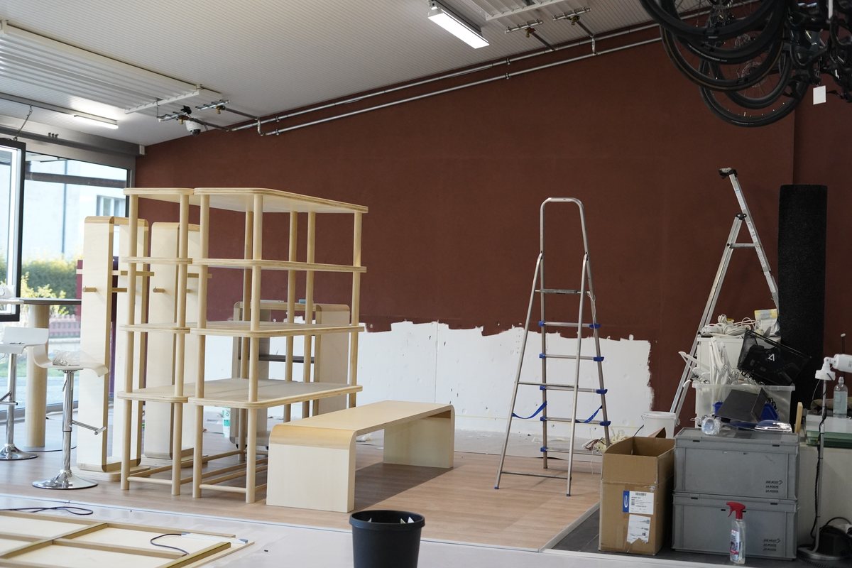 Rayonnages en cours de montage devant le mur rouge